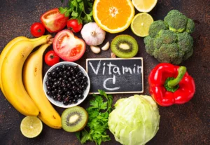 eine Auswahl an Obst und Gemüse mit einer Tafel, auf der Vitamin C steht