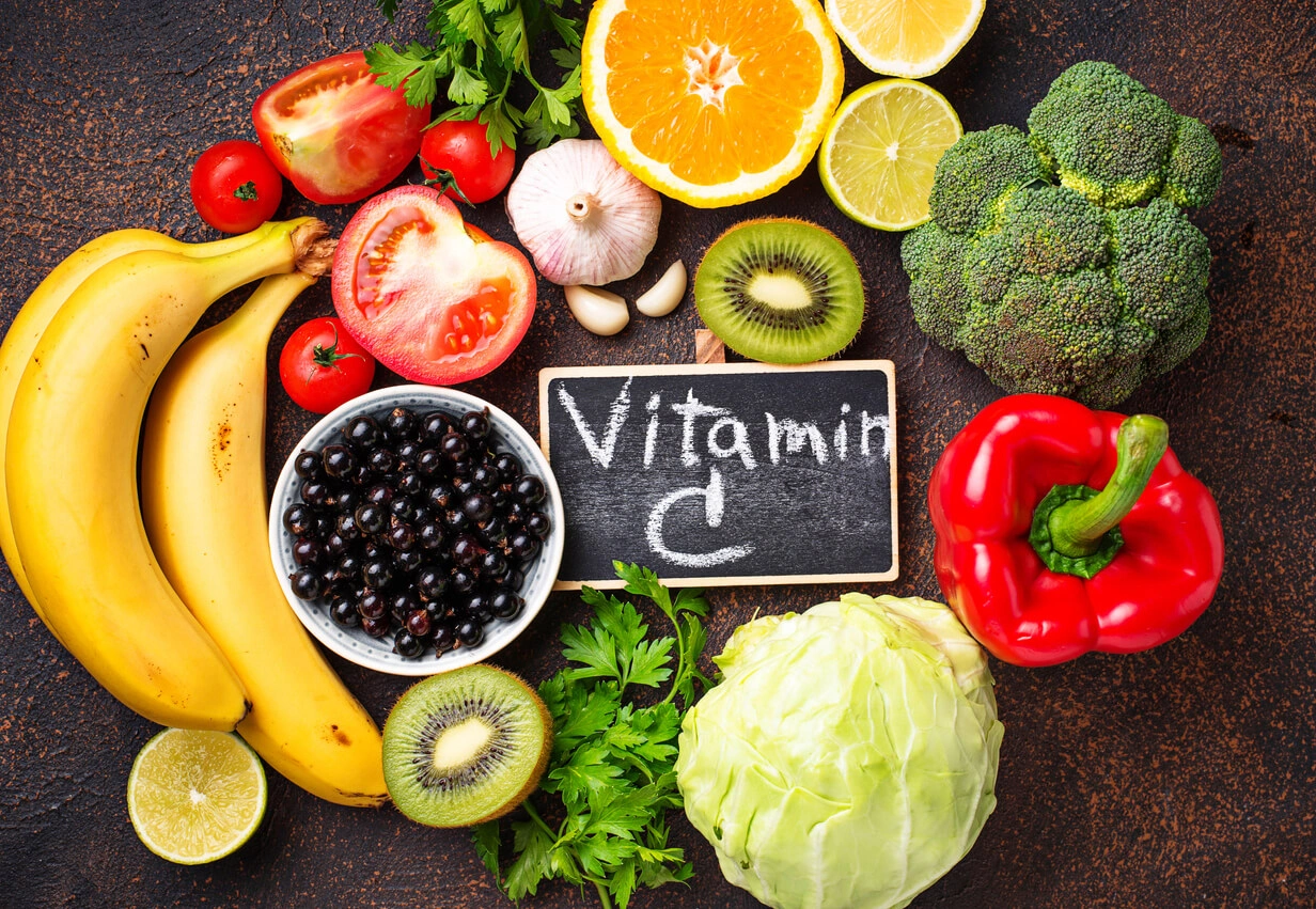 eine Auswahl an Obst und Gemüse mit einer Tafel, auf der Vitamin C steht